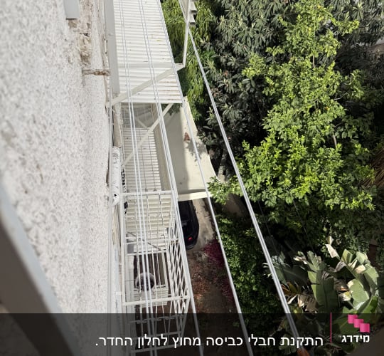 מרפסת עם חבלי כביסה ועצים ברקע